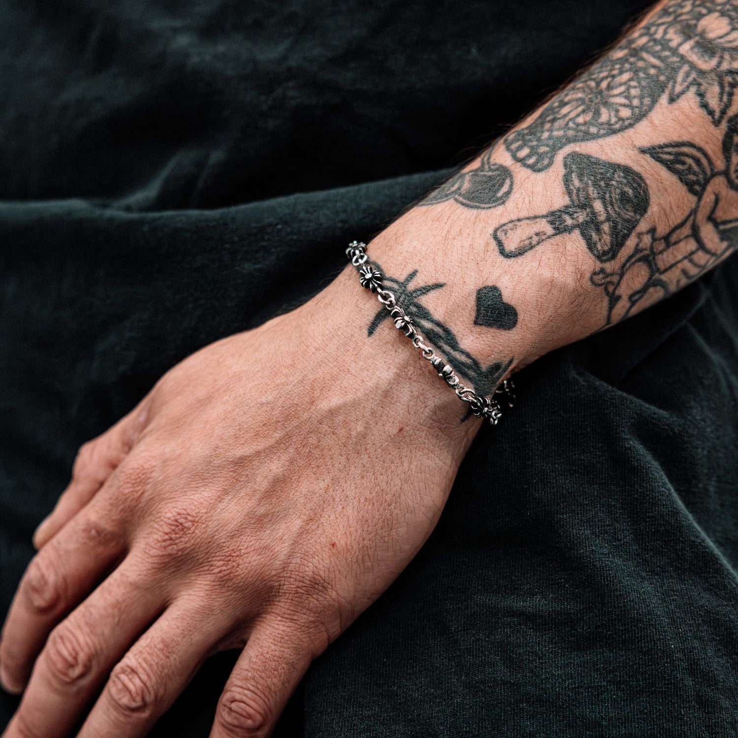 Hand with a bracelet and tattoo on a dark background