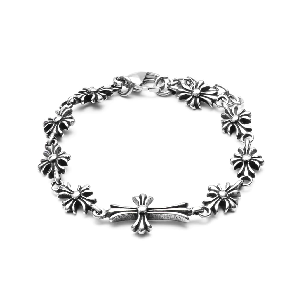 Silver bracelet with floral and cross designs on a white background